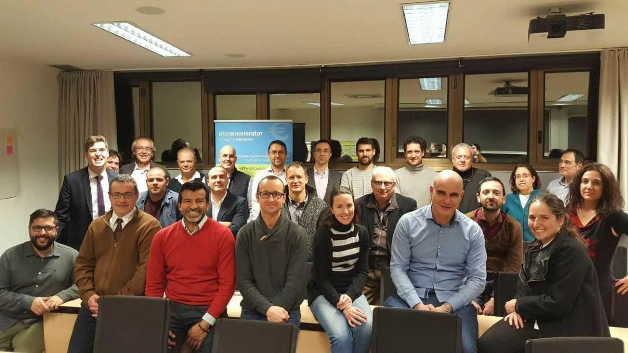El equipo de 2 Digits Growth posando en una sala de reuniones de Esade, con el roll-up de la aceleradora al fondo