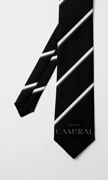 Corbata negra de rayas diagonales blancas con el nombre Hotel Camiral